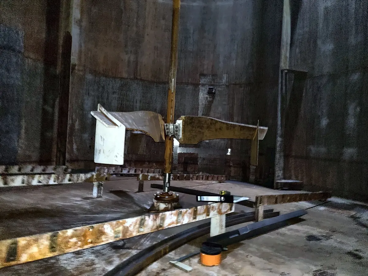 Girante inferiore dell’agitatore imbullonata sull’albero dentro un serbatoio di stoccaggio, con il supporto sul fondo al di sotto