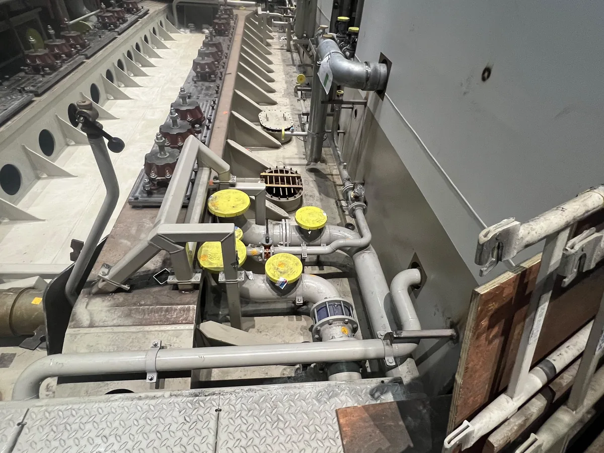 Una fila di supporti elastici lungo il basamento lavorato, con le prime linee e flange tappate posate a fianco
