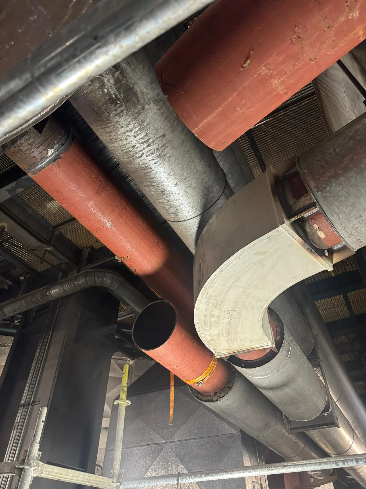 Neue Rohrleitungen großer Nennweite und ein gefertigter Bogen, eingebaut zwischen vorhandenen Leitungen und Kanälen in einer Industrieanlage